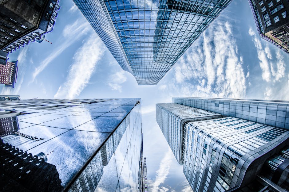 Low angle shot of modern skyscrapers in Frankfurt, showing reflections and sky.